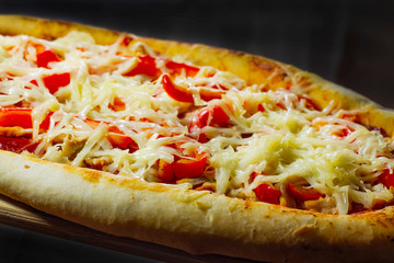 Aromatic pizza with sausage and tomatoes is decorated with cheese