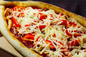 Aromatic pizza with sausage and tomatoes is decorated with cheese