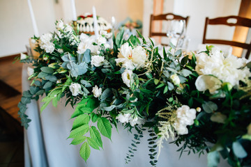 Wedding reception table decorated with fresh flowers and greenery