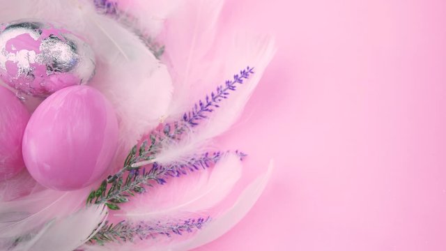 Beautiful Easter eggs are painted in pink and silver colors. Nest of lavender flowers and feathers with eggs. High quality HD video. Video in pink pastel colors. Motion video from right to left. 