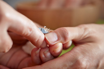 Nail care service at salon, removing cuticle with nail nipper 