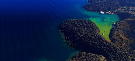 Aerial drone ultra wide photo of famous volcanic crater of Palaia Kameni with green sea in centre of Santorini island, Cyclades, Greece