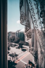 Window with lace curtain and cityscapes outside the window