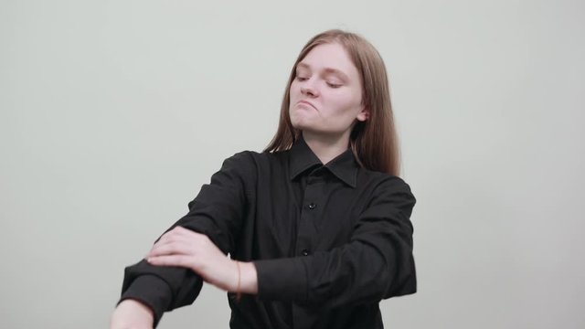 Disappointed young woman in fashion black shirt isolated on gray background in studio keeping hands crossed, looking at camera. People sincere emotions, lifestyle concept.