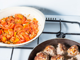 Cooking delicious homemade tomato, onion and carrot sauce for meatballs on the stove