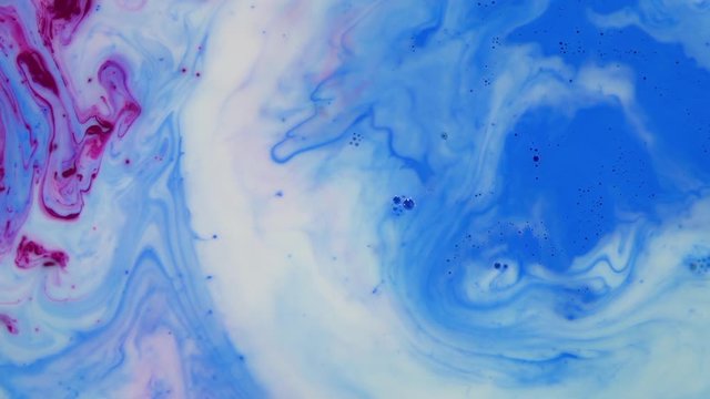 Liquid Colorful Paint pattens mix in slow motion. Liquid color paint patterns texture top view. Multicolor liquid paint surface.