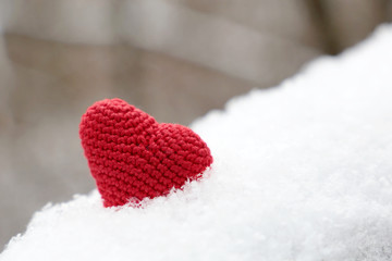 Love heart, Valentine's card, red knitted symbol of passion in the snow. Background for romantic...