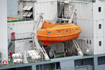 Red lifeboat docked to ship