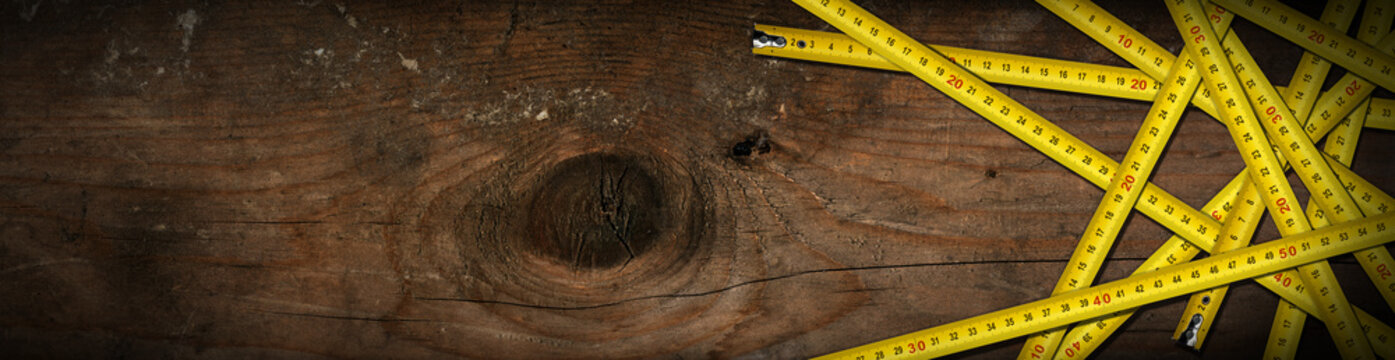 Close-up of many tape measures on a wooden table with copy space, horizontal photography