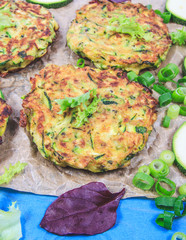 Zucchini pancakes with chives on a wooden table. - 313609948