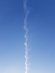 Inversion trail of an airplane in the blue sky