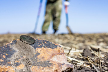 an old penny of Tsar Nicholas the second Emperor of Russia, found during excavations using a metal detector on an abandoned fortress, the front and background blurred with the effect of bokeh