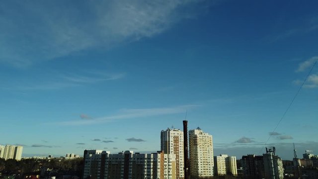 Motionlapse of view on a blue sky. Small clouds floating in the daily sky over the downtown. High resolution