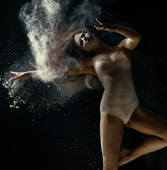 Fototapeta na wymiar Amazing photo of graceful woman dancing with dust