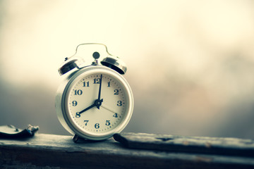 white vintage clock  on the desk