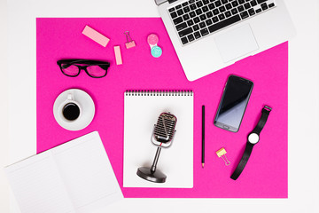 promotion of social networks. stationery, microphone, phone and laptop are on a pink table