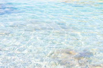 Fototapeta na wymiar Background made of clean transparent blue water sea surface. Mediterranian sea surface on sunny day with waves and flares. Copy space.