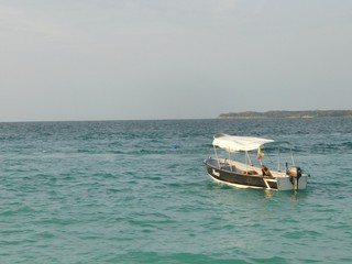 Fototapeta na wymiar Barco en mar de varios colores