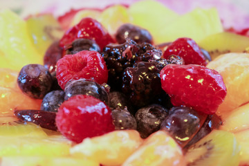 Primo piano di una torta di compleanno alla frutta con candeline 61 anni 