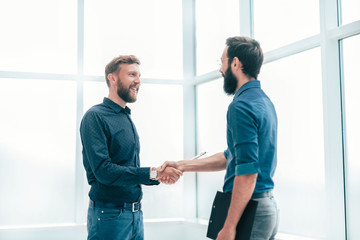 smiling business people shaking hands in the office.