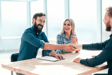 smiling young man answering employers ' questions during the interview