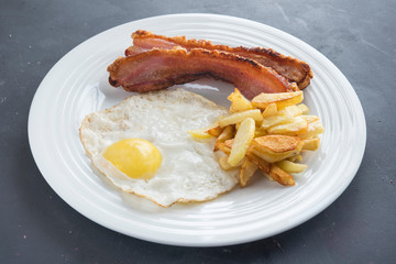 slice of bacon, egg and potatoes chips in white background