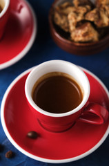 Red Mug of aromatic espresso on a blue table.