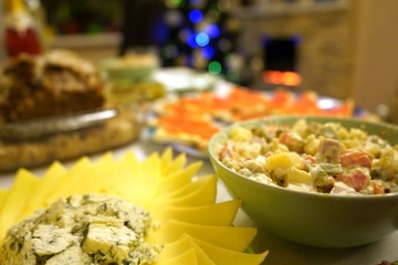 Dishes with food on the New Year's holiday table. New Year's holiday table. Salads, meat, alcohol on the New Year's table.
