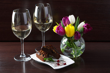  brownie cake on a dark background with a bouquet of tulips