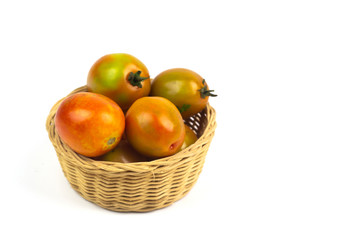 Tomatoes in the basket isolated on white background.