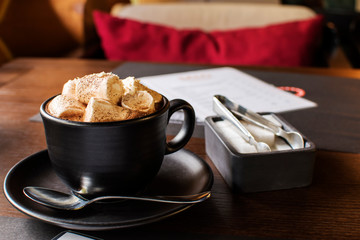 cup hot chocolate with cinnamon and marshmallows on wooden background