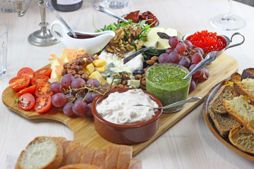  holiday big cheese plate with grapes olives sun-dried tomatoes nuts sauces and red caviar