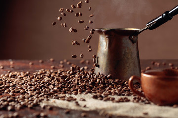 Falling coffee beans and old copper coffee maker.