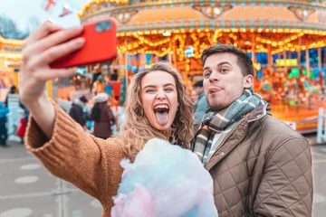 Photo sur Plexiglas Parc dattractions Couple having fun and taking a selfie at amusement park in London