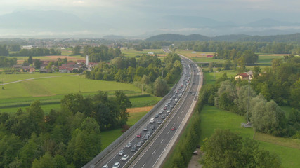 AERIAL Flying along long traffic jam formed on highway crossing the countryside