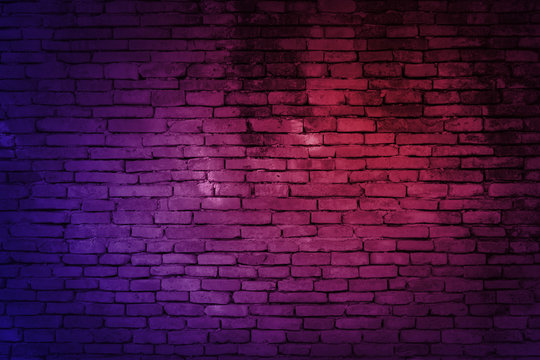 Neon light on brick walls that are not plastered background and texture. Lighting effect red and blue neon background of empty brick basement wall. © lllonajalll