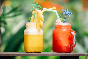 Refreshing cocktail on the table with palms