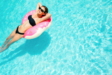 Enjoying suntan woman in bikini on the inflatable mattress