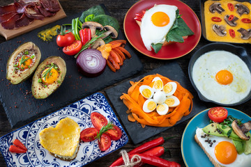 Fried eggs with avocados on the black table with many types of spices