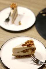 Slice of vegan cake with walnuts, cashew nuts and raisins. Selective focus.