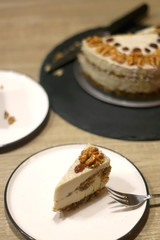 Slice of vegan cake with walnuts, cashew nuts and raisins. Selective focus.