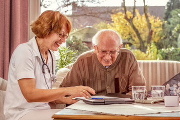 Female Doctor Looking After Ederly Person at Home