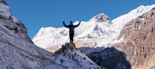 Mountaineer cheering on top of a rock, Dhaulagiri Circuit Trek, Himalaya, Nepal