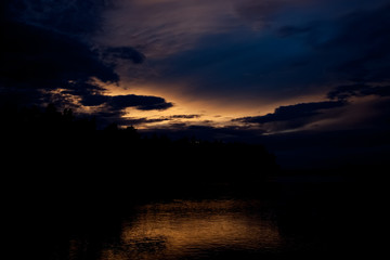Fototapeta na wymiar Thunderstorm over the sea horizon during sunset. 