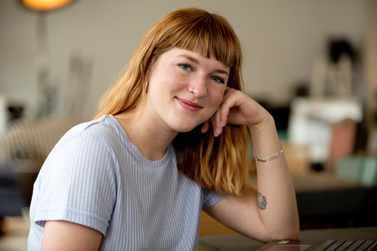 Portrait of strawberry blonde young woman with nose piercing in a coffee shop