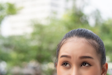 stressed upset thoughtful asian woman thinking, looking up; portrait of asian woman looking up, thinking, finding good idea or decisive plan; adult southeast asian woman model