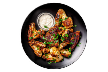 Baked chicken wings in Mexican with curry seasoning and parsley on a black plate, on a wooden background. side view, copy space, top view