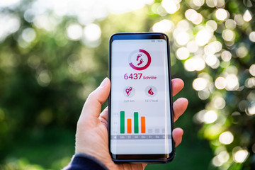 Woman holding smartphone, using fitness app