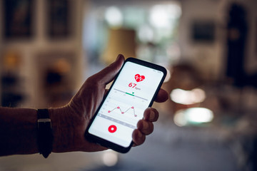 Senior holding smartphone, using fitness app