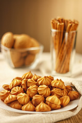 Cookies in a white plate on a white tablecloth